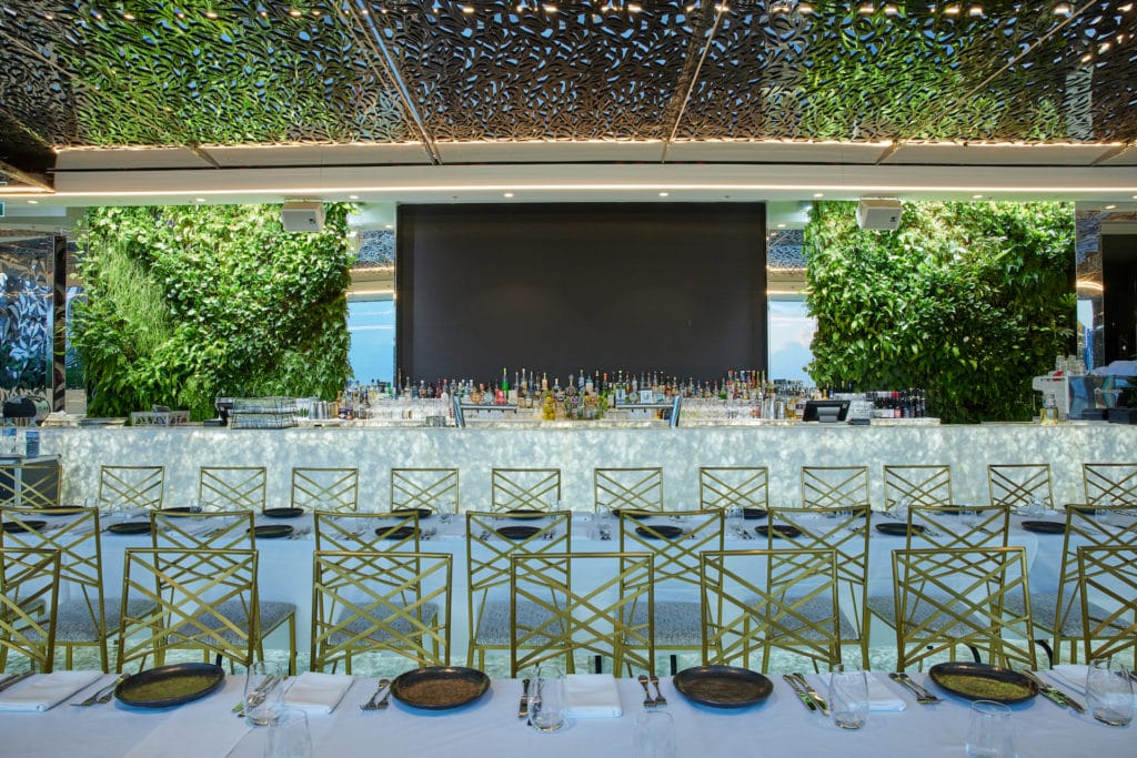 The green walls and table set up at Emporium South Bank Brisbane's The Terrace rooftop restaurant and bar.
