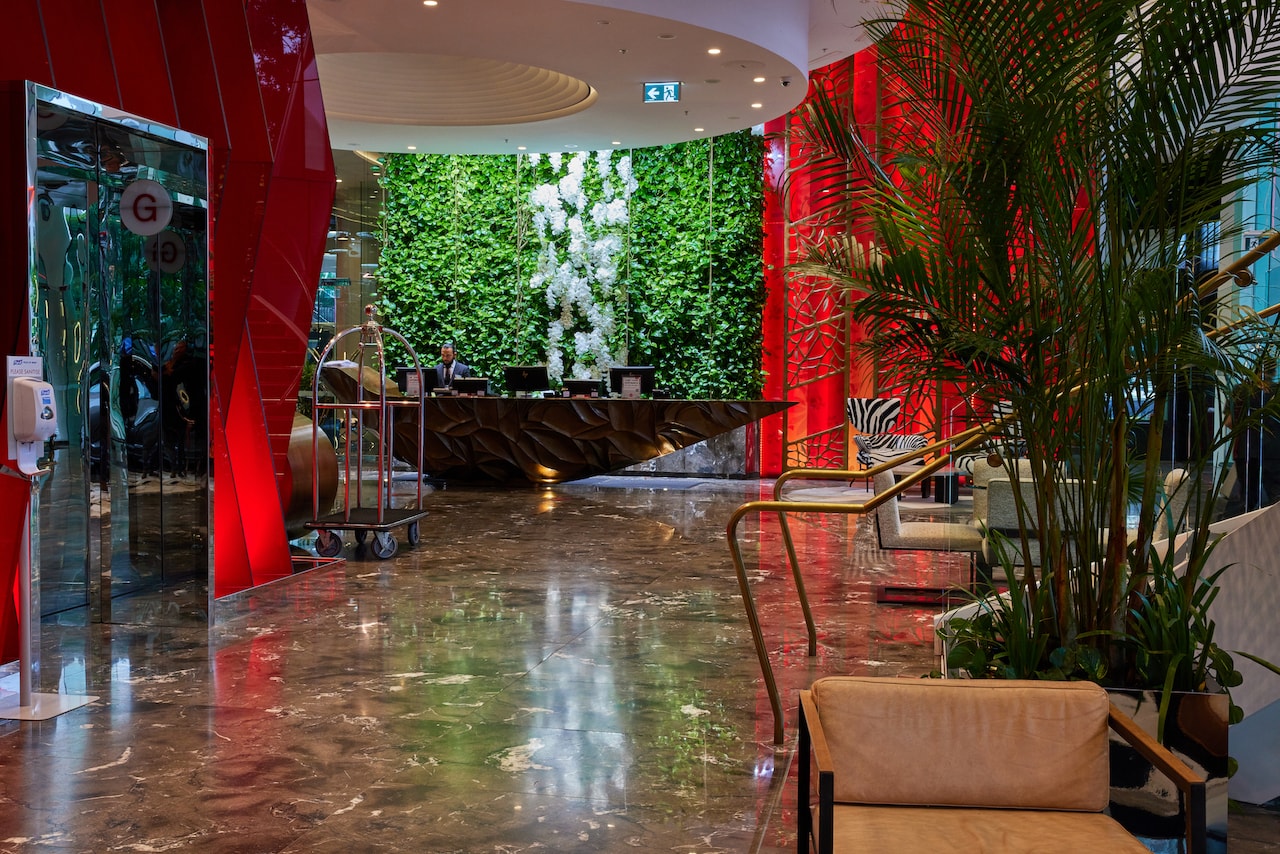 The striking lobby of Emporium South Bank Brisbane, featuring a living green wall behind reception.