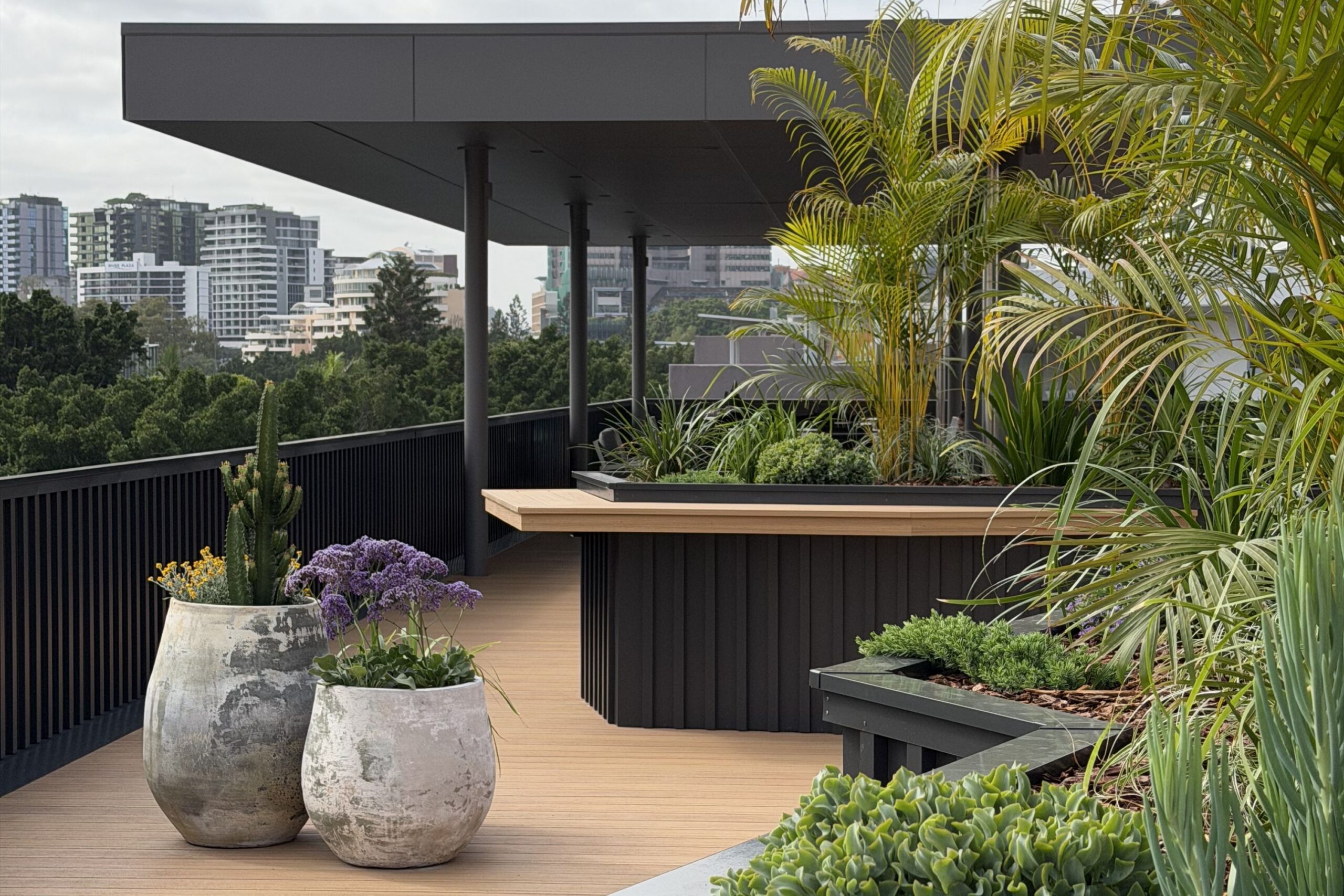 ooftop terrace planted with palms, succulents and flowering sea lavender in weathered stone pots and built-in planters, overlooking a city skyline